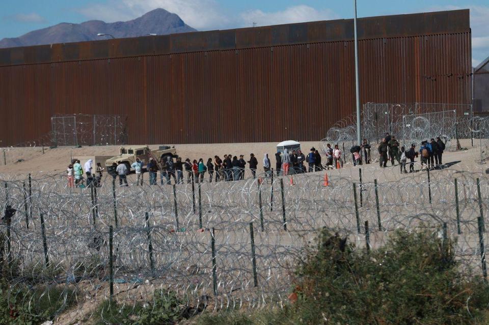 Migrants at the US southern border wall in Juarez City, Mexico