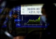 FILE PHOTO: An electronic screen displaying Japan's Nikkei share average and stock prices is seen through a car in Tokyo