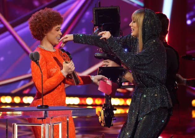 Ice Spice, left, presents Taylor Swift with the award for song of the year for 