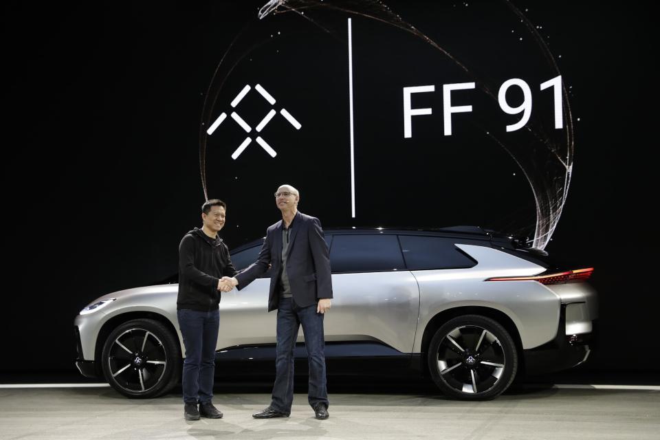 LeEco CEO Jia Yueting, left, and Nick Sampson, Faraday Future's senior vice president of product research & development, shake hands after unveiling the FF91 electric car at CES International Tuesday, Jan. 3, 2017, in Las Vegas. (AP Photo/Jae C. Hong)