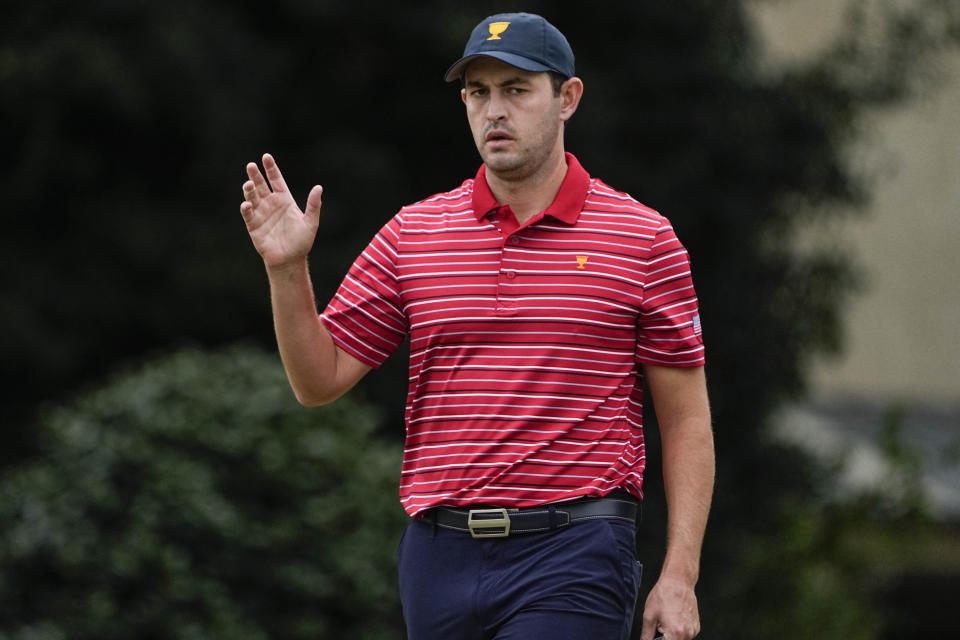 Patrick Cantlay waves after his birdie putt on the third green during their singles match at the Presidents Cup golf tournament at the Quail Hollow Club, Sunday, Sept. 25, 2022, in Charlotte, N.C. (AP Photo/Chris Carlson)