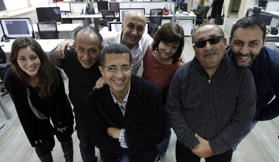 Moustafa Bassiouni, second from right, stands for a group photo with AP staff in Cairo on Nov. 30, 2011. From left are Nariman El-Mofty, Manoocher Deghati, Amr Nabil, Nasser Nasser, Maya Alleruzzo, Moustafa and Khalil Hamra. Bassiouni, an intrepid photo assistant and driver for The Associated Press’ Cairo bureau, has died at age 64. His family said he died in a Cairo hospital on Saturday, June 10, 2023, after experiencing a heart attack. (AP Photo)