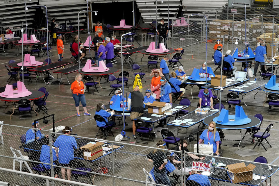 FILE - Maricopa County ballots cast in the 2020 general election are examined and recounted by contractors working for Florida-based company, Cyber Ninjas at Veterans Memorial Coliseum in Phoenix, May 6, 2021. (AP Photo/Matt York, Pool, File)