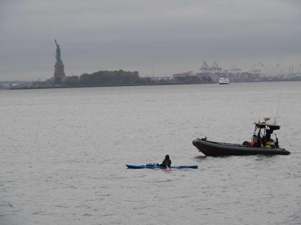 Man swimming past the statue of liberty