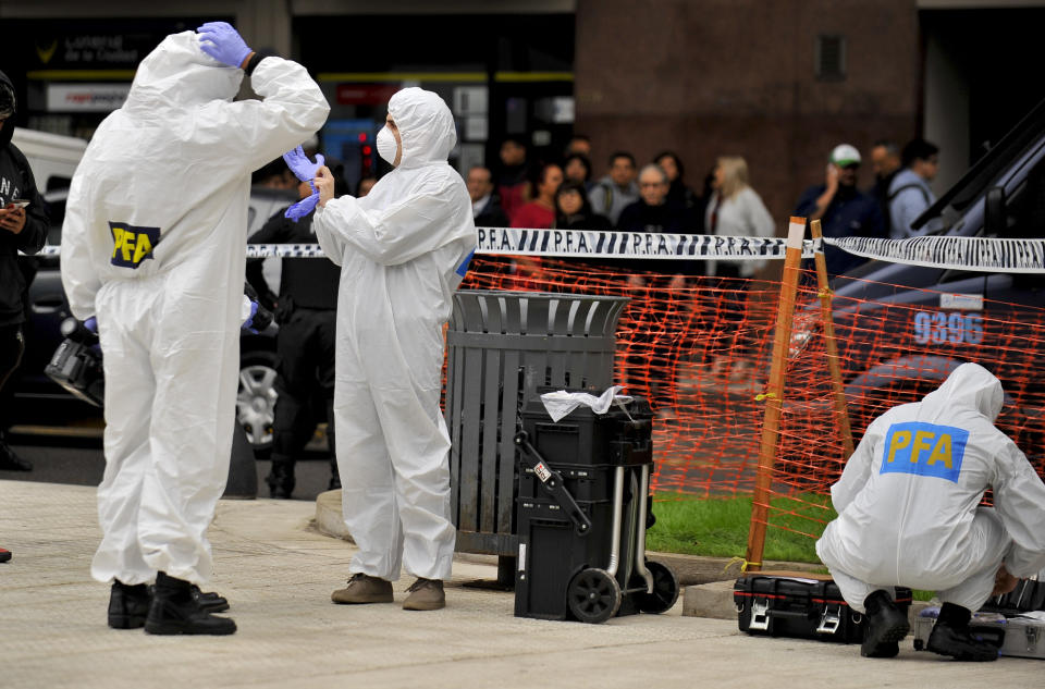 CORRECTS TO CHANGE FROM MOVING VEHICLE TO PARKED CAR - Police collect evidence at the crime scene where Argentine lawmaker Hector Olivares was seriously injured and another man was killed after they were shot at from a parked car near the Congress building in Buenos Aires, Argentina, Thursday, May 9, 2019. Officials say Olivares was shot at around 7 a.m. local time. Olivares is a representative of La Rioja province in Argentina's lower house of Congress. He is being treated at a hospital in Buenos Aires. (AP Photo/Natacha Pisarenko)