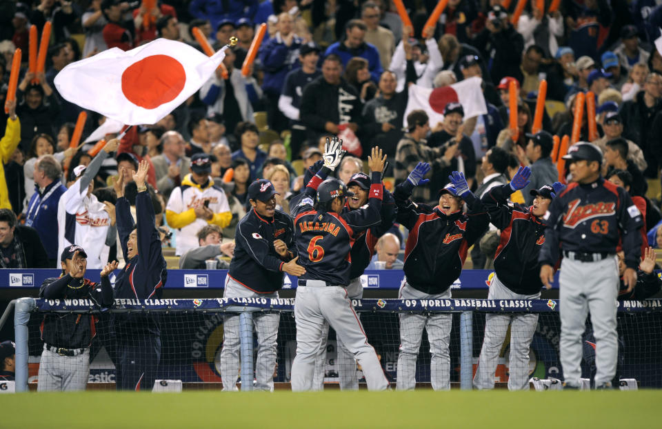 FILEL - In this March 23, 2009 file photo, Japan celebrates on the field after beating South Korea 5-3, in the final of the World Baseball Classic in Los Angeles. The Japanese players' association agreed to take part in the 2013 World Baseball Classic Tuesday, Sept. 4, 2012, backing off from a threat to boycott the event over the way tournament revenue is shared. (AP Photo/Mark J. Terrill, File)