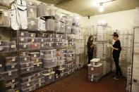 In this photo taken Wednesday, April 9, 2014, marketing manager Kate Systrom, left, and receiving manager Leslie Armstrong look over jewelry inside a vault at the headquarters of The RealReal in San Francisco. At left is shelving filled entirely with Louis Vuitton items. An explosion of resale online sites from RealReal to Chairish that allows shoppers to easily trade in their gently used top brand handbags, furniture and gadgets for cash is changing the way Americans buy. The ease of reselling their possessions allows consumers to keep refreshing their wardrobes and homes without feeling guilty. (AP Photo/Eric Risberg)