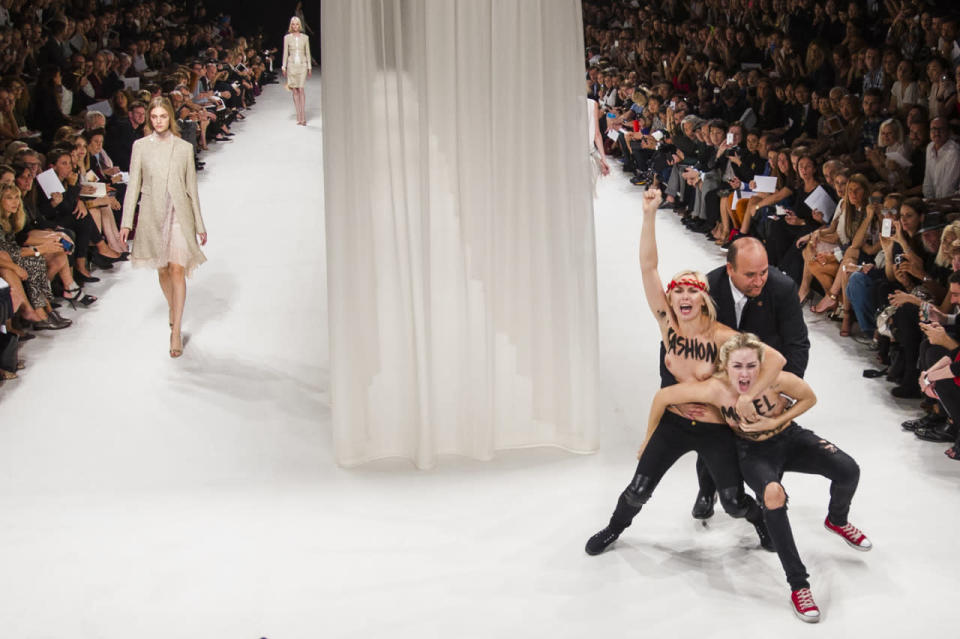 Ukrainian feminist protest group Femen stormed the catwalk at Paris Fashion Week Womenswear Spring/Summer 2014, their bodies painted with the words ‘model don’t go to brothel’