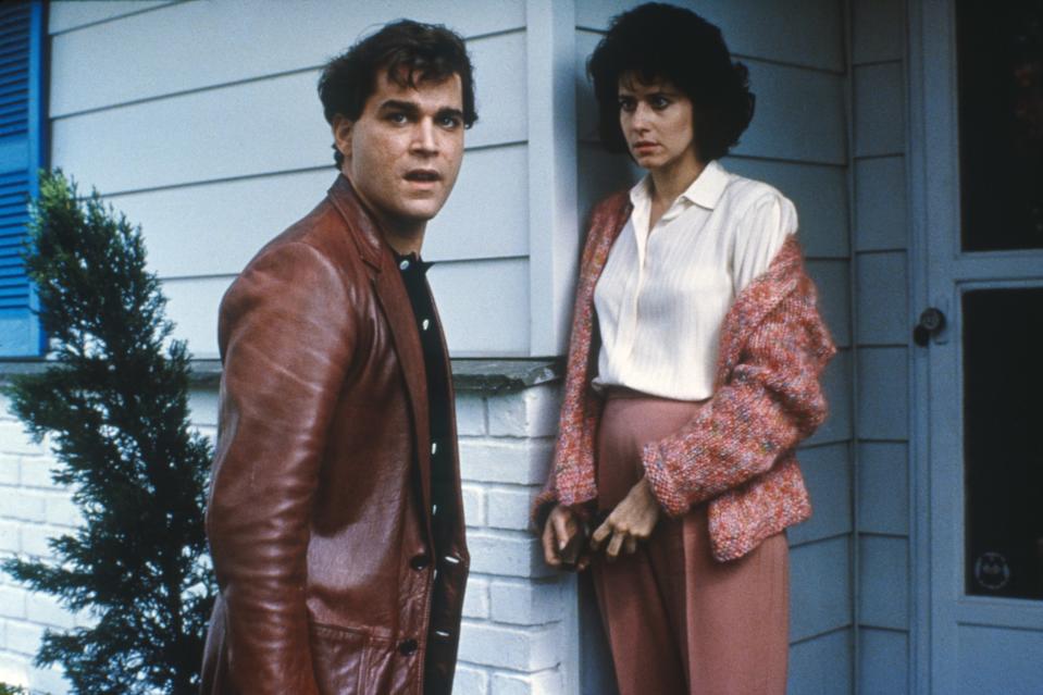 couple standing outside of a house