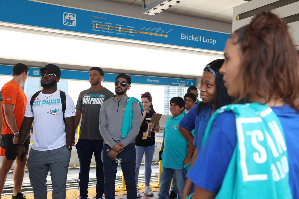 Members of the Miami Dolphins rookie class, left, participates in a historic walking tour of Downtown Miami with local community groups like students from Miami PAL, Miami Police Athletic League, right, on Wednesday, June 15, 2022, beginning with tour leaders at the History Miami Museum.
