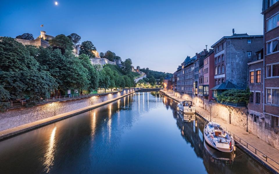 Belgium, Namur Province, Namur, Motorboats moored along city canal at dusk