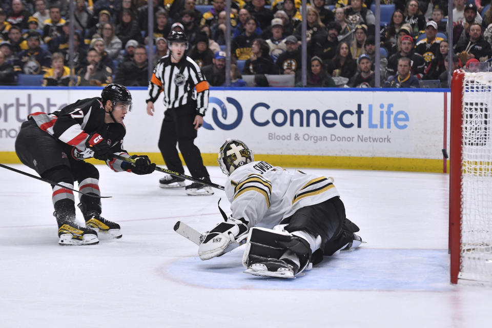 Buffalo Sabres right wing JJ Peterka, left, puts a shot wide of Boston Bruins goalie Jeremy Swayman and the net during the second period of an NHL hockey game in Buffalo, N.Y., Wednesday, Dec. 27, 2023. (AP Photo/Adrian Kraus)