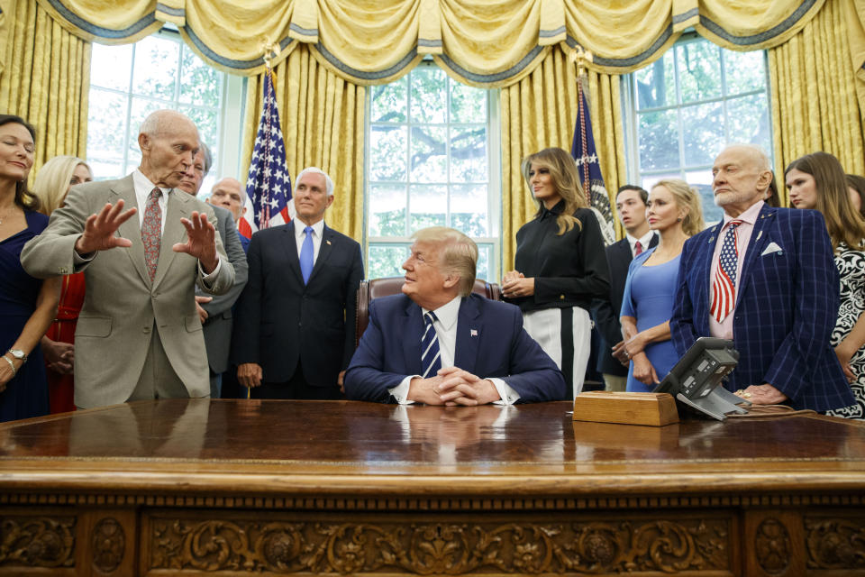 El presidente Donald Trump, acompañado por los astronautas Michael Collins, izquierda, y Buzz Aldrin, derecha, del Apolo 11, así como por el vicepresidente Mike Pence y la primera dama Melania Trump, escucha durante una reunión para conmemorar el 50mo aniversario del alunizaje del Apolo 11, en la Oficina Oval de la Casa Blanca, el viernes 19 de julio de 2019, en Washington. (AP Foto/Alex Brandon)