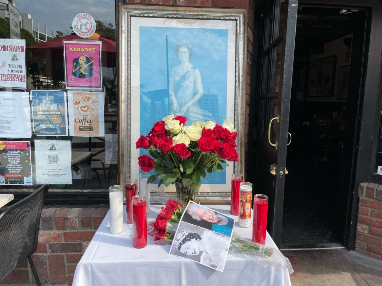 At Ye Olde Kings Head, in Santa Monica, a shrine dedicated to the monarch, featuring candles, roses and pictures was placed outside (Mike Bedigan/PA)