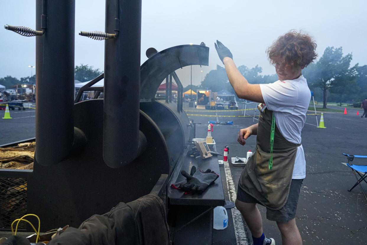 Danathan Hughston opens the Cedar Creek team's smoker to check its brisket.