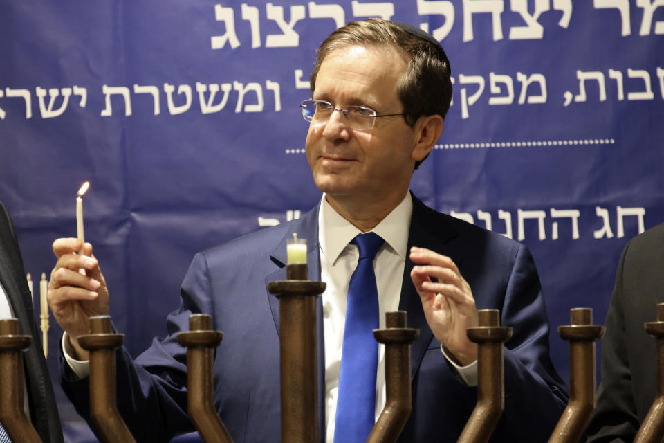 Israeli President Isaac Herzog lights candles during the Jewish holiday of Hanukkah in Hebron's holiest site, known to Jews as the Tomb of the Patriarchs and to Muslims as the Ibrahimi Mosque in the Israeli controlled part of the West Bank city of Hebron, Sunday, Nov. 28, 2021, Sunday, Nov. 28, 2021. (AP Photo/Oren Ziv)