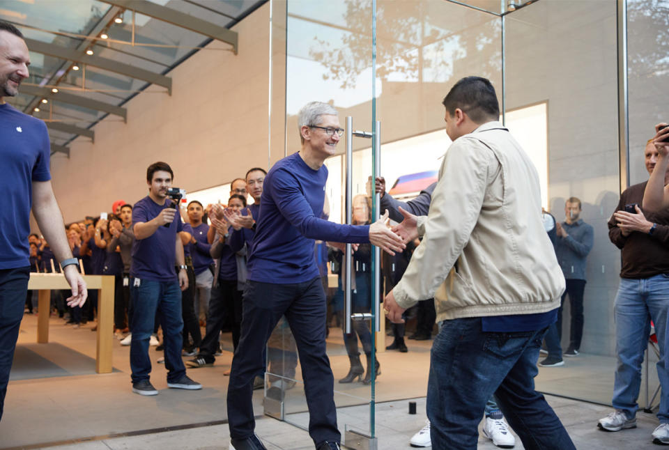 Apple CEO Tim Cook greets a customer at an Apple Store on the iPhone X launch day