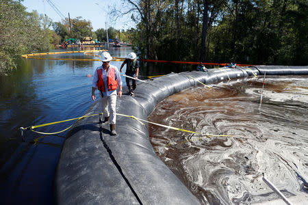 Santee Cooper workers check the water levels around a 6000 foot long Aqua Dam built to keep sediment from a coal ash retention pond from going into the flooded Waccamaw River in the aftermath of Hurricane Florence in Conway, South Carolina, U.S. September 26, 2018. REUTERS/Randall Hill