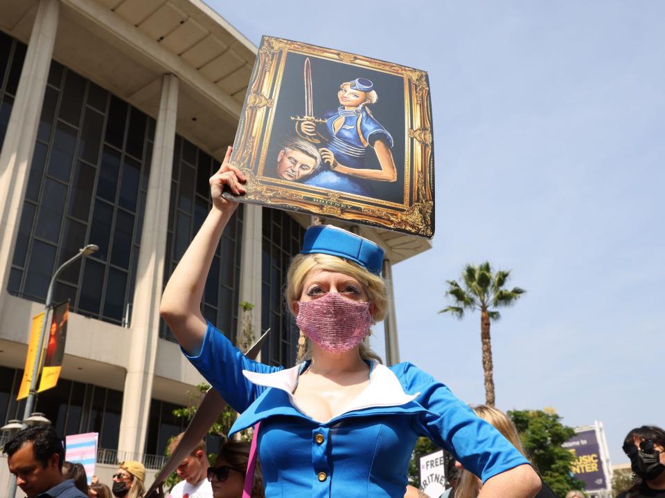 Nefertara, an artist from Los Angeles, California, holds an image of a painting she made of Britney Spears holding her beheaded father, Jamie Spears.