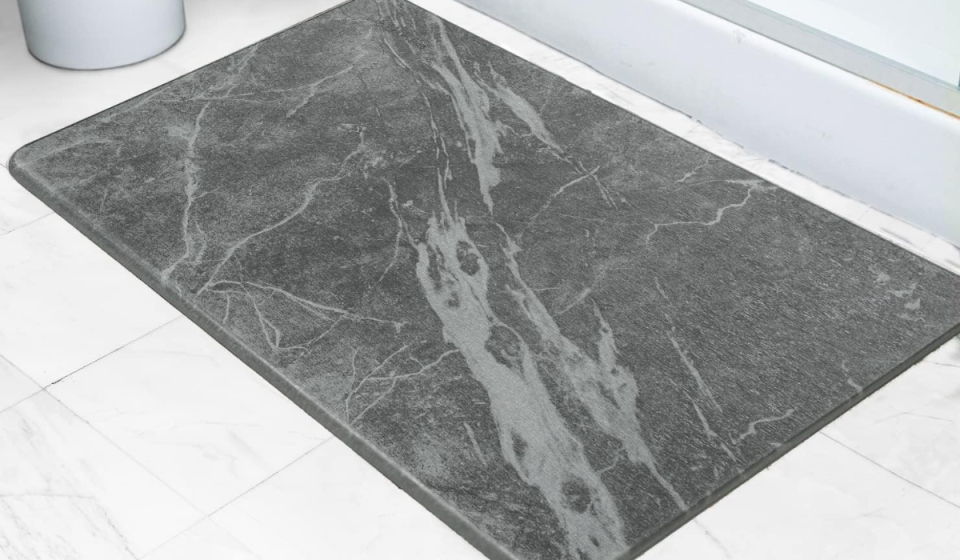 the gray marble-print bath mat in front of a shower