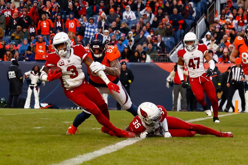 Budda Baker #3 of the Arizona Cardinals tackled by Eric Saubert #82 of the Denver Broncos after an interception during the third quarter at Empower Field At Mile High on Dec. 18, 2022, in Denver, Colorado.