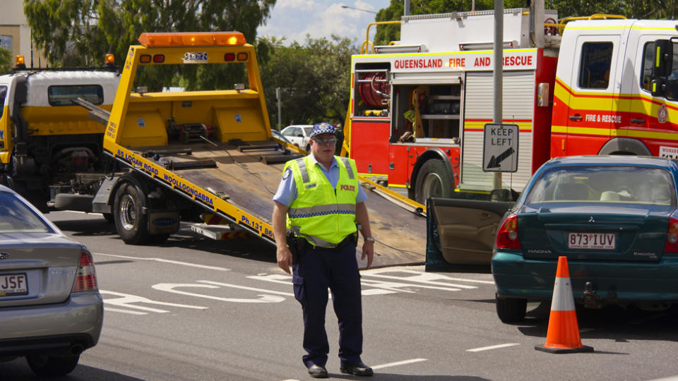 New laws require drivers to slow down when passing emergency vehicles. Pictured is a police officer at the scene of a car accident.