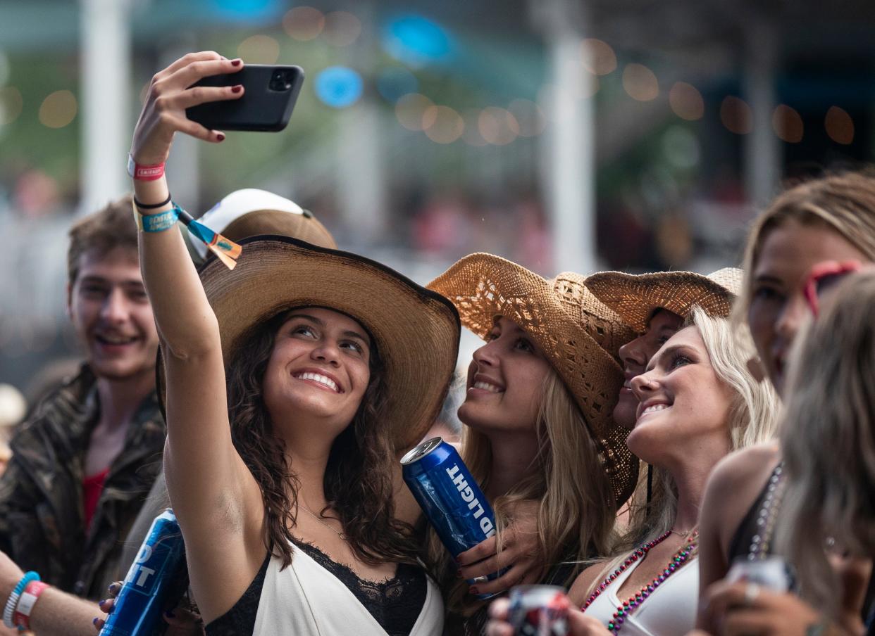 Country music fans take selfies as they wait for Carly Pearce to perform at the main stage during the Faster Horses Country Music Festival in Brooklyn on July 16, 2021.