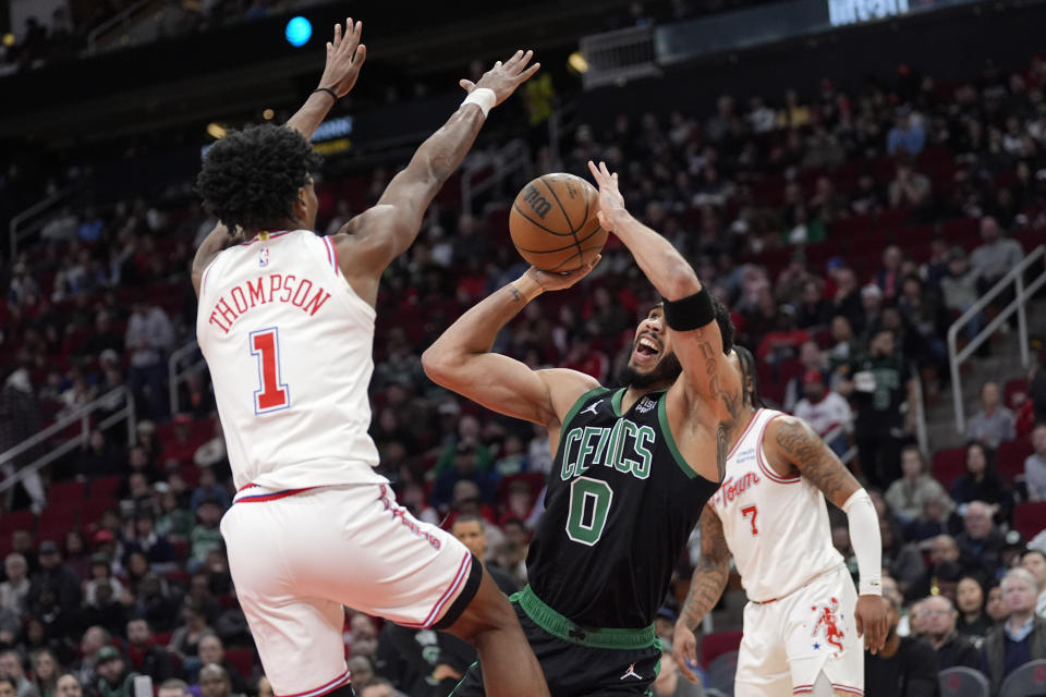 Boston Celtics' Jayson Tatum (0) shoots as Houston Rockets' Amen Thompson (1) defends during the first half of an NBA basketball game Sunday, Jan. 21, 2024, in Houston. (AP Photo/David J. Phillip)