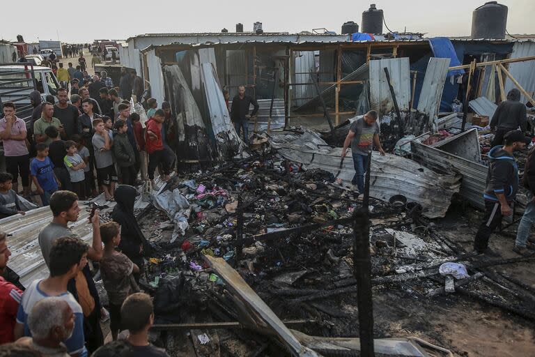 Palestinos observan la destrucción tras un ataque israelí donde se alojaban personas desplazadas en Rafah, Franja de Gaza, lunes 27 de mayo de 2024. 