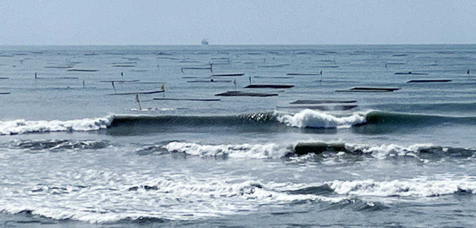 台南沿海掀起巨浪，台南市浮筏式牡蠣養殖的蚵棚載沉載浮。（記者陳治交攝）