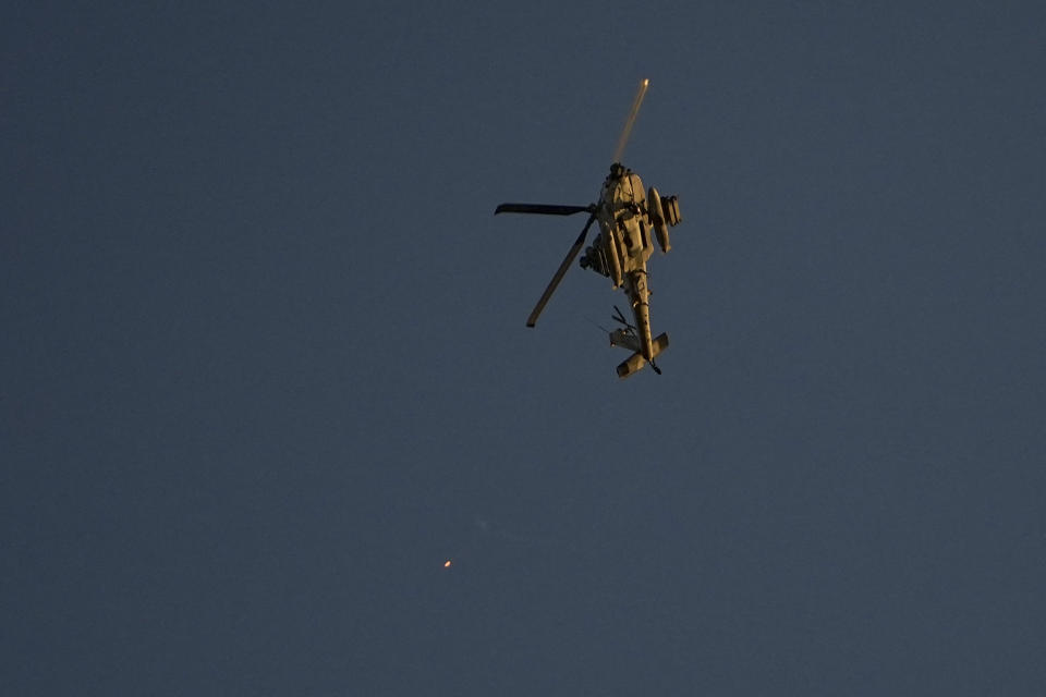 An Israeli Apache helicopter fires flares over the Gaza Strip on Friday, Dec. 1, 2023. (AP Photo/Ariel Schalit)