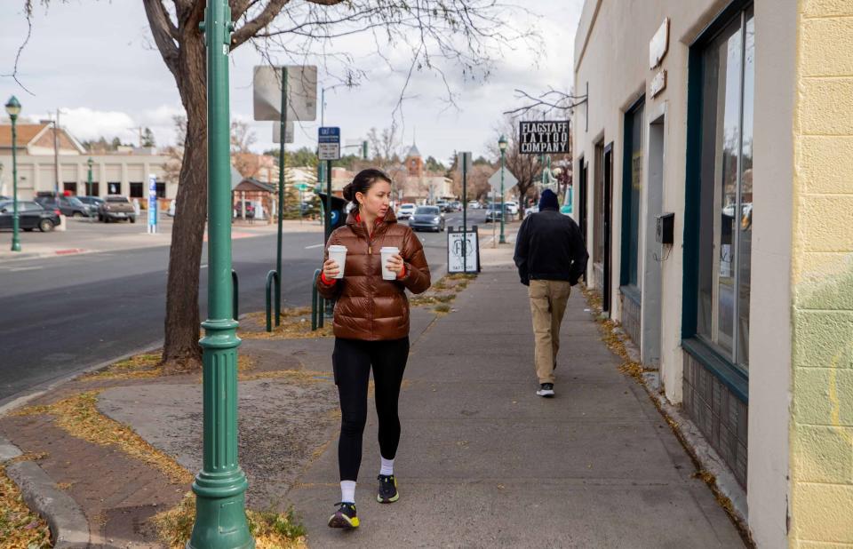 People walk down the street wearing sweaters and jackets as temperatures drop in Flagstaff on Nov. 16, 2023.