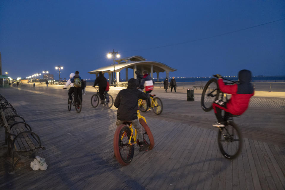 Boys ride their bikes on the Coney Island boardwalk, Wednesday, March 10, 2021 in New York.  / Credit: Mark Lennihan / AP