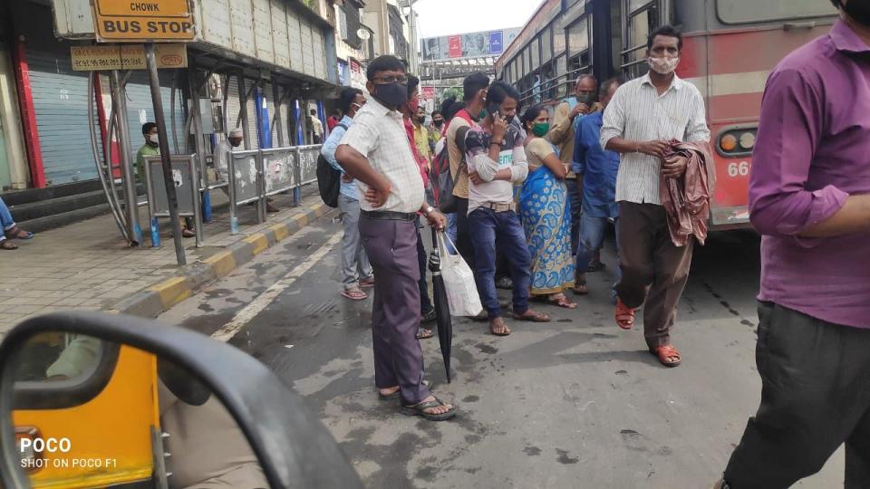 Crowd at a bus stop.