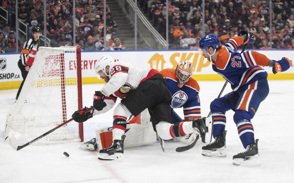 Ottawa Senators' Claude Giroux (28) is stopped by Edmonton Oilers goalie Stuart Skinner (74) as Brett Kulak (27) defends during the third period of an NHL hockey game Saturday, Jan. 6, 2024, in Edmonton, Alberta. (Jason Franson/The Canadian Press via AP)