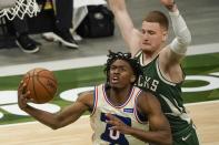 Philadelphia 76ers' Tyrese Maxey drives past Milwaukee Bucks' Donte DiVincenzo during the first half of an NBA basketball game Saturday, April 24, 2021, in Milwaukee. (AP Photo/Morry Gash)