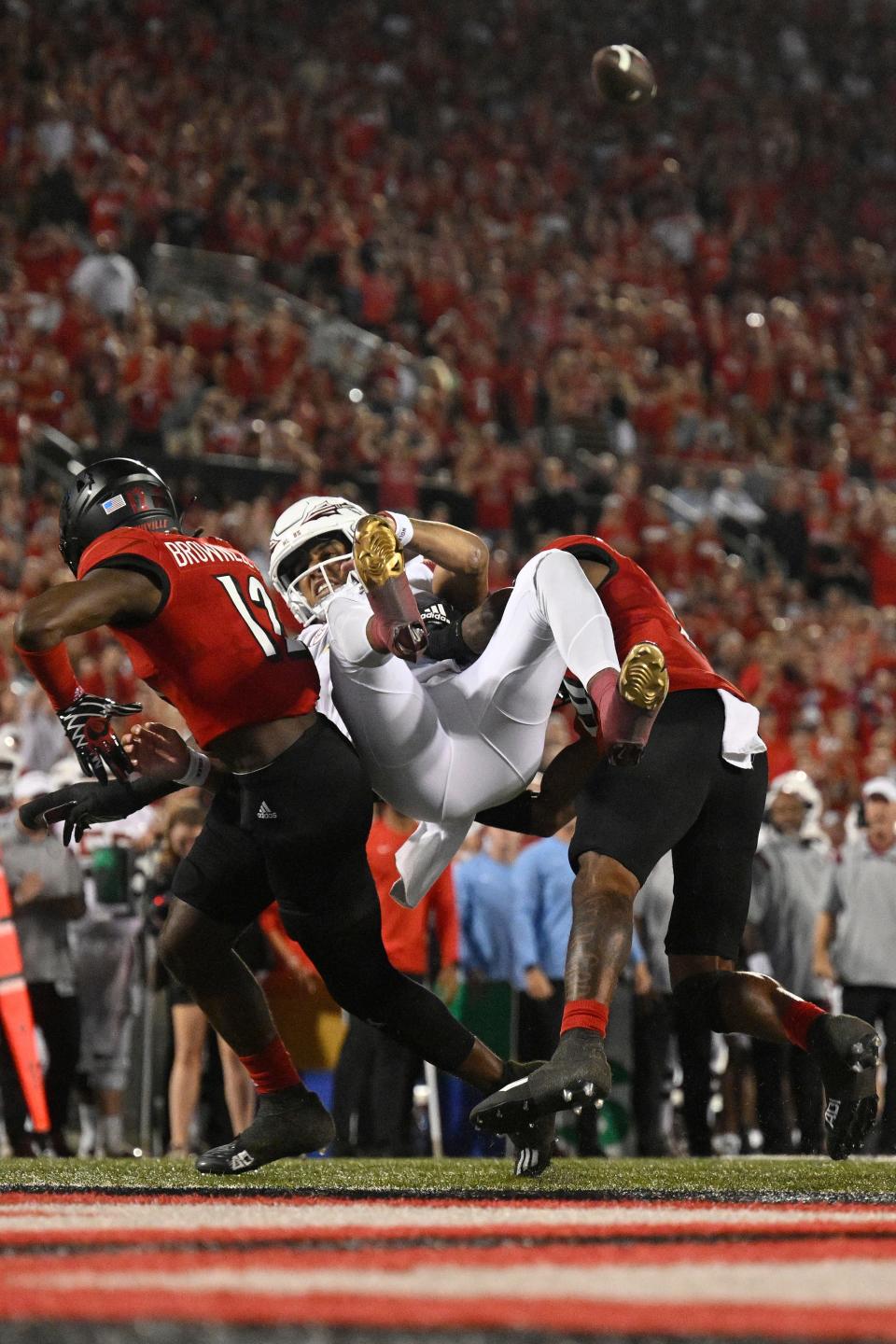 Jarvis Brownlee (12) and Ben Perry (10) hit FSU quarterback Jordan Travis during a September 2022 game in Louisville.