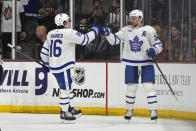 Toronto Maple Leafs center Auston Matthews (34) celebrates with right wing Mitchell Marner after scoring his 50th goal of the season, against the Arizona Coyotes during the first period ofan NHL hockey game Wednesday, Feb. 21, 2024, in Tempe, Ariz. (AP Photo/Rick Scuteri)