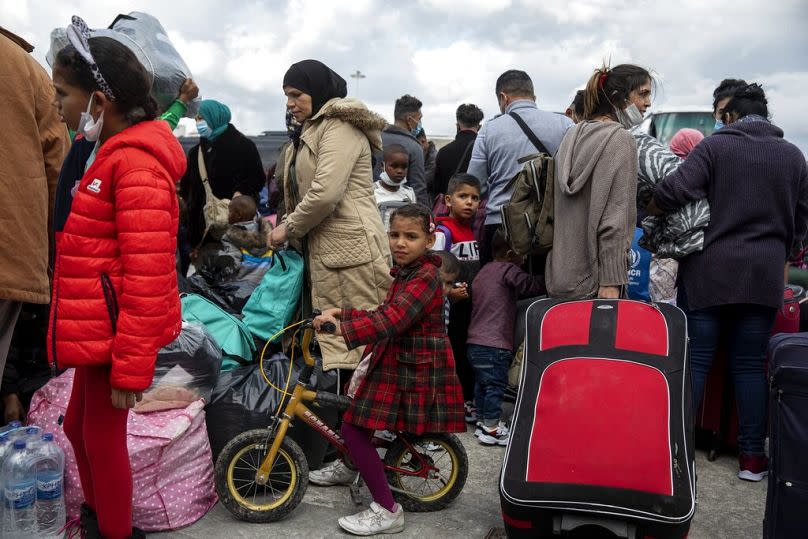 Migrants from camps from the eastern Aegean islands wait to board on buses after their disembarkation from a ship, at the port of Lavrio, November 2020