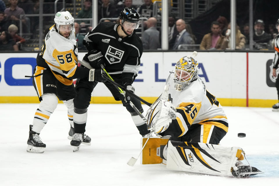 Pittsburgh Penguins goaltender Magnus Hellberg, right, deflects a shot by Los Angeles Kings center Adrian Kempe, center, as defenseman Kris Letang defends during the second period of an NHL hockey game Thursday, Nov. 9, 2023, in Los Angeles. (AP Photo/Mark J. Terrill)