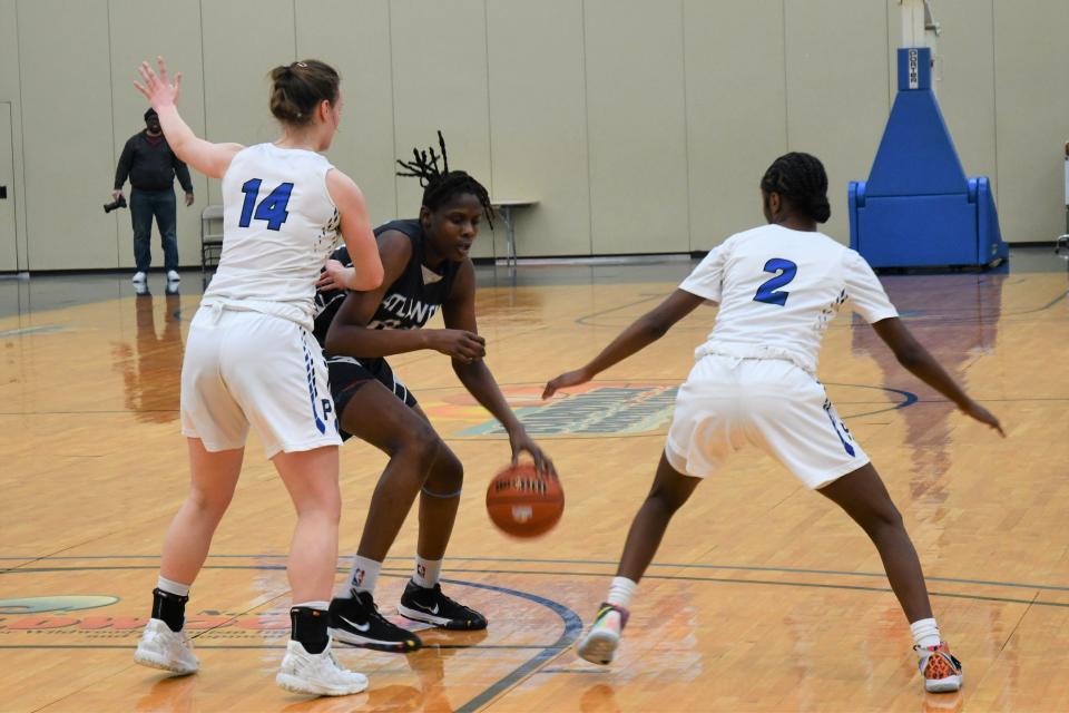 Atlantic City forward Quanirah Montague spins out of a double team between Paul VI forward Sarah McShea and help defender Sharia Baynes