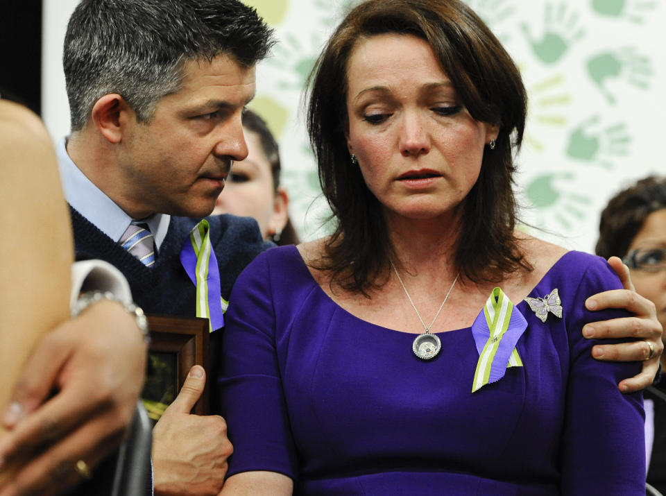 FILE - Ian and Nicole Hockley, parents of Sandy Hook School shooting victim Dylan, listen at a news conference at Edmond Town Hall in Newtown, Conn., Monday, Jan. 14, 2013. After agreeing to a $73 million lawsuit settlement with gun-maker Remington, the families of nine Sandy Hook Elementary School shooting victims say they are shifting their focus to ending firearms advertising. (AP Photo/Jessica Hill, File)