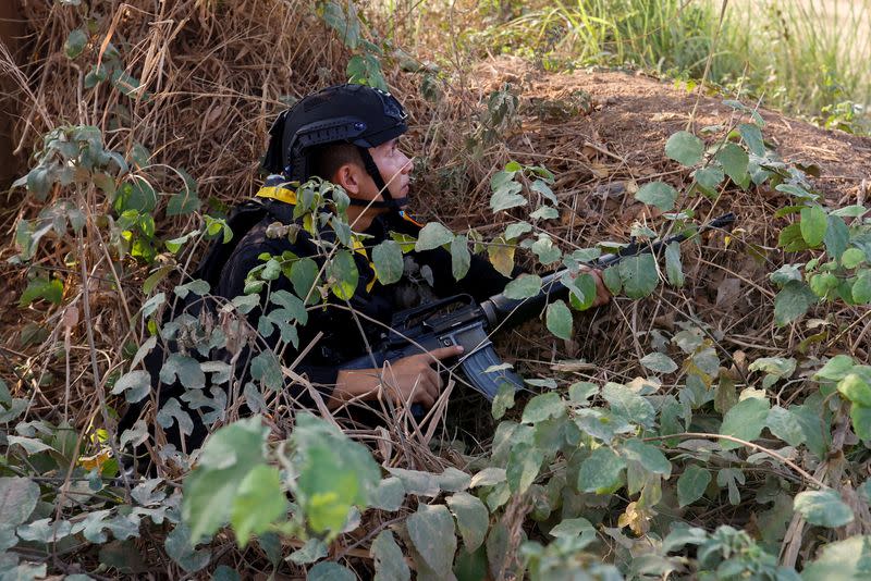 A Thai soldier takes cover near the 2nd Thailand-Myanmar Friendship Bridge during fighting on the Myanmar side between the Karen National Liberation Army (KNLA) and Myanmar's troops, which continues near the Thailand-Myanmar border