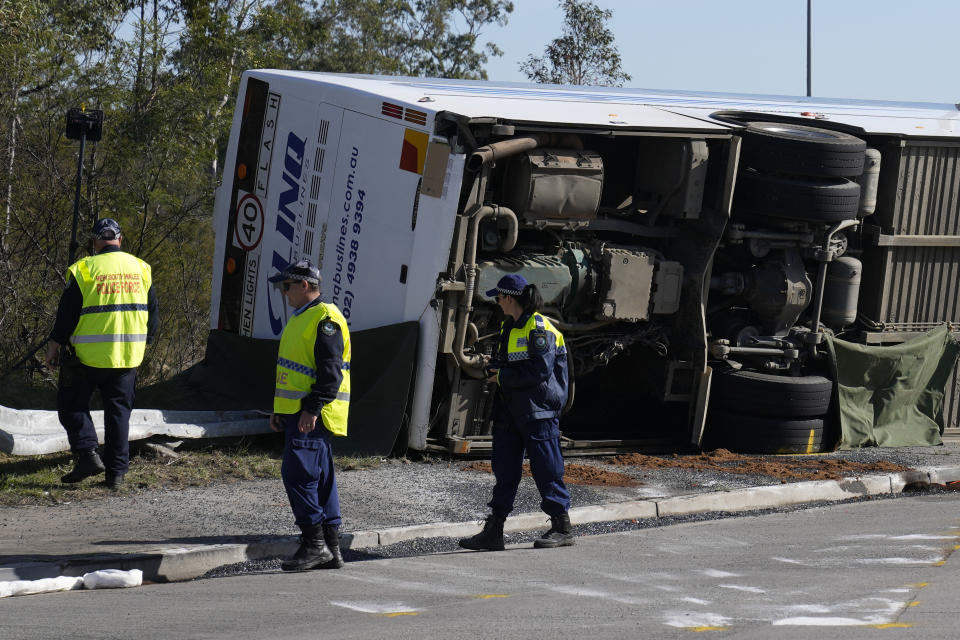 Police inspect the bus on its side after it rolled over on a foggy night, killing and injuring multiple people. Source: AAP