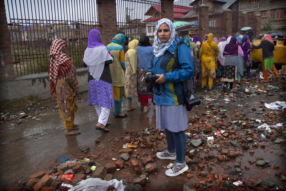 In this Oct. 4, 2019. photo, Kashmiri photojournalist Masrat Zahra stands for a photograph during a protest on the outskirts of Srinagar, Indian controlled Kashmir. ‘I’ll kick you with my boots and take you to the governor’s house,’ a policeman told photojournalist Masrat Zahra as she covered the first Friday protest since the Aug. 5 lockdown. “Women cannot move out of their homes without a male companion for fear of harassment,” she says. But adds “you cannot remain silent. If you come out and speak, someone will hear your voice. Coming out to work is my way of protesting.” (AP Photo/ Dar Yasin)