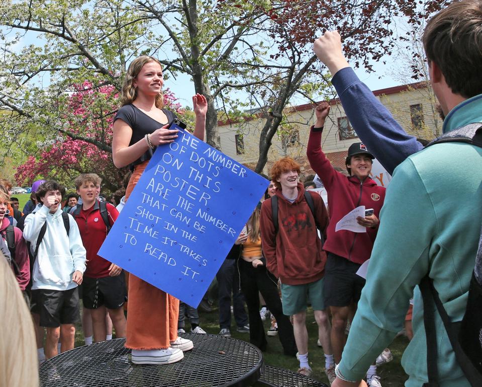 Portsmouth High School students organized a walkout against gun violence May 9, 2023. Gabby Rothstein stands on a table to speak with students and communicate that they will march to the football field.