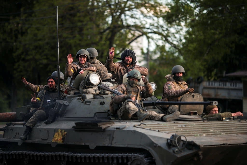 Ukrainian service members wave as they ride on top of an armoured vehicle, amid Russia's attack on Ukraine, in Kharkiv.  (REUTERS)