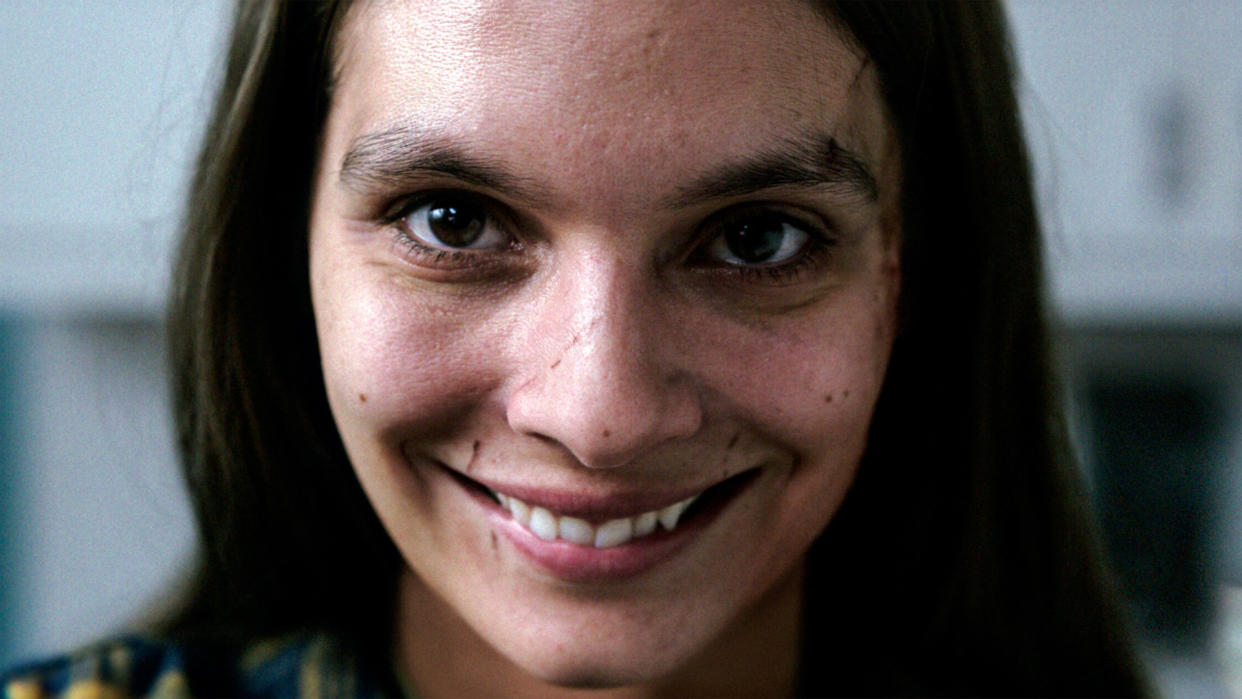  A woman grinning scarily at the camera in Smile. 