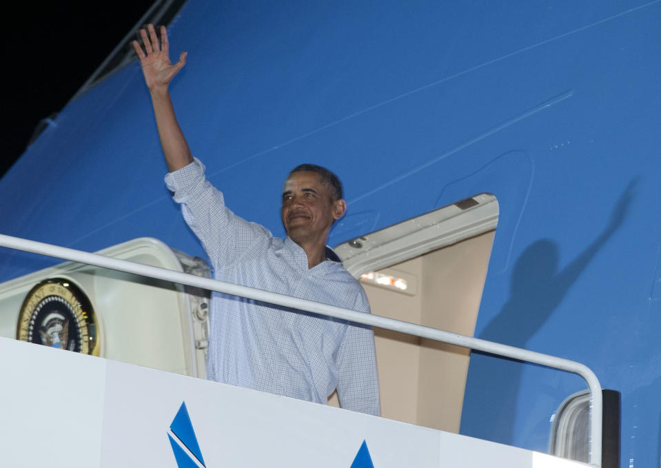 President Barack Obama waves as he boards Air Force One at Honolulu Joint Base Pearl Harbor-Hickam, in Honolulu, Saturday, Jan. 4, 2014, as they travel back to Washington after their annual family vacation. (AP Photo/Carolyn Kaster)