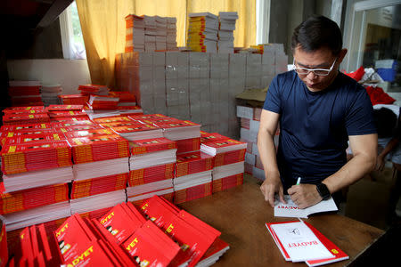 Ferdinand Tan, 53, wealth coach and motivational speaker, signs his books on financial advice in his home in Cainta City, Rizal province, Philippines, November 30, 2018. When Tan is not at his speaking engagements, he works from home. His employees, both full-time and part-time, also work from home. REUTERS/Eloisa Lopez